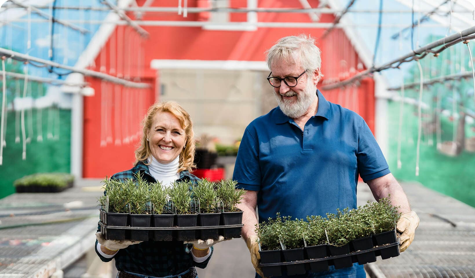 woman and man happily carrying plants